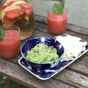 bol de guacamole aux algues sur une table en bois avec deux verres de gaspacho