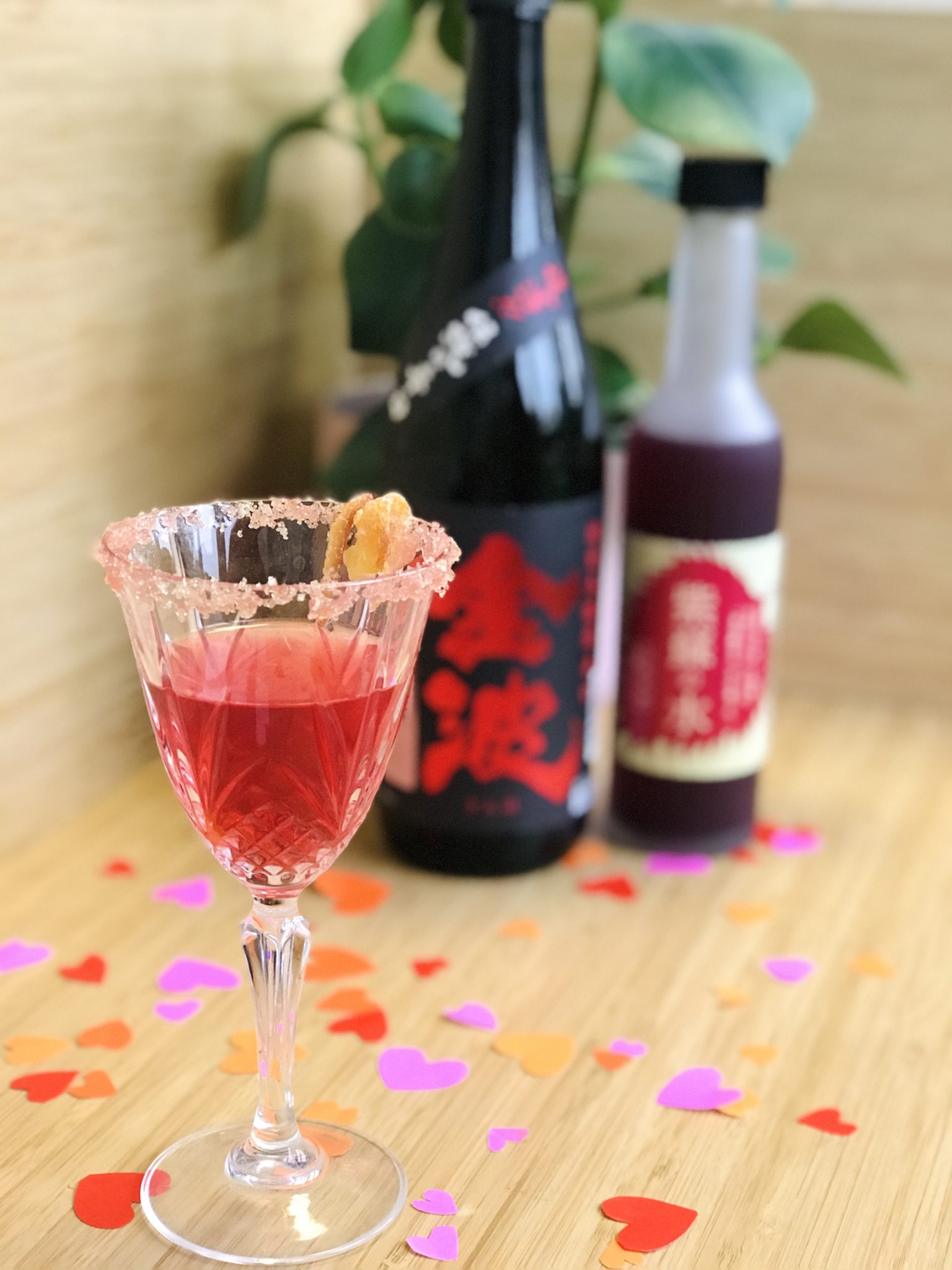 cocktail rose de saint valentin au saké et sirop de shiso avec du gin et des ecorces de iyokan