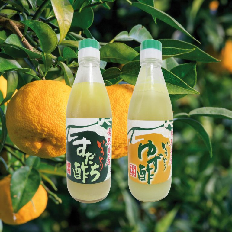 Bouteilles de jus d'agrumes japonais yuzu et sudachi sur une image de fruits yuzu en fond