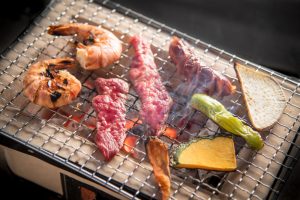 crustacés, viande et légumes en train de griller sur un barbecue japonais au binchotan