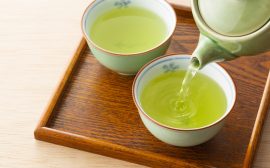 deux tasses de thé vert avec théière dans un plateau en bois