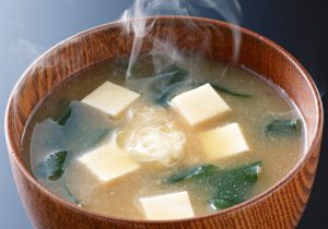 Soupe miso avec morceaux de tofu et de wakame servi dans un bol en bois