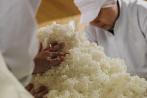deux personnes brassant du riz pour faire du saké