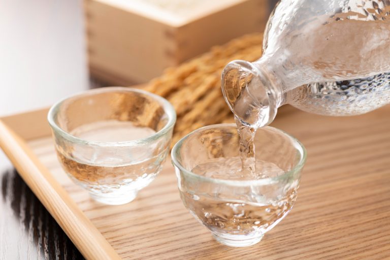 Saké versé dans deux ochoko en verre