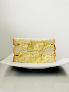 sandwich aux oeufs dans assiette blanche et fond blanc