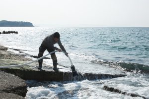 Suezawa Teruyuki qui aspire l’eau de mer