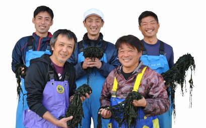 Photo de 5 japonais, avec des tabliers, qui tiennent des algues dans leurs mains