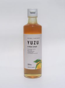 Bouteille de sirop de yuzu sur fond blanc