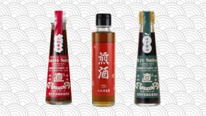 trois bouteilles de sauce soja sur un fond japonais au motif de vague grises