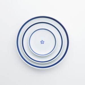 Vue de haut de trois assiettes en porcelaine japonaise avec motif bleu, sur fond blanc 