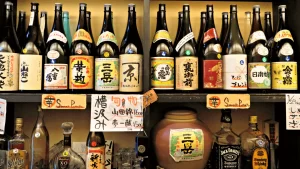 étagère avec une rangée de bouteilles de shochu japonaises